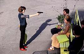Photo of a participatory performance with a woman holding a fake gun